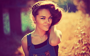 shallow focus photo of woman wearing blue denim dungaree