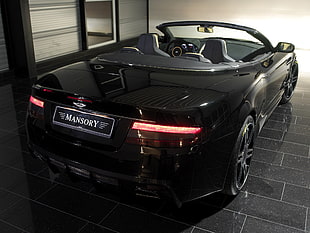 black Aston Martin Mansory convertible coupe parked on black tiled floor HD wallpaper