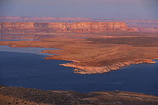 brown rocky mountain with body of water