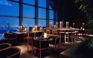 brown-and-black wooden dining tables with chairs set near in glass window