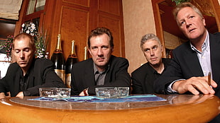 three men in black tops sitting in front of table with four rocks glasses HD wallpaper