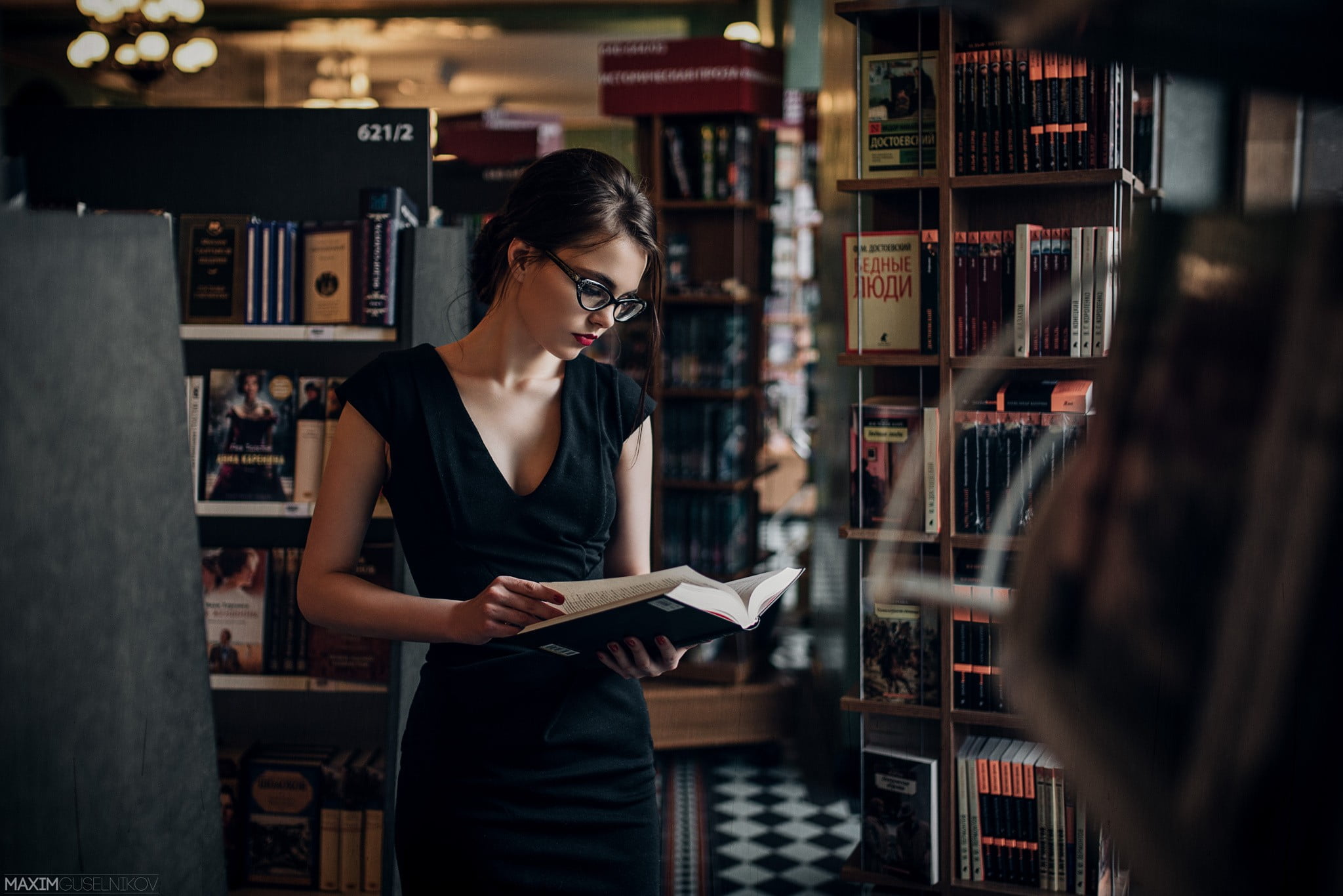 woman with black plunging neckline short-sleeved bodycon reading book