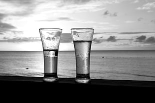 two clear glass candle holders, glasses, beach