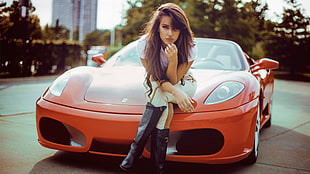 woman sitting on red Ferrari convertible