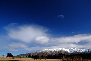 landscape photography of snow covered mountains under cumulus clouds