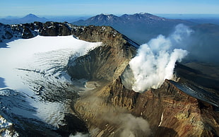 aerial view of crater lake with smoke during day time