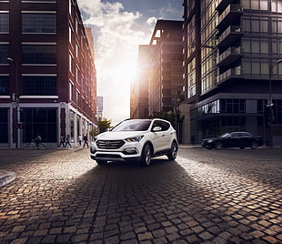 white Hyundai SUV parked on between two high rise buildings