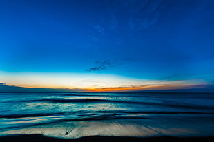 time lapse photo of sea by the shore during sunset