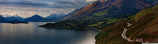 calm body of water near mountains