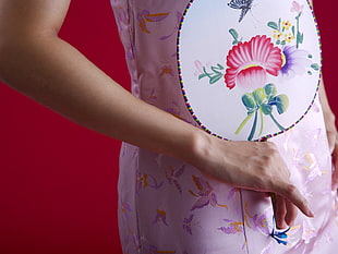 person's hand touching pink floral textile