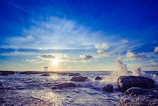 sea waves crushing in stones during sunset