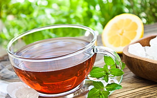 shallow focus photography of clear glass tea on brown wooden table