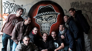 photo of nine man beside beige skull painted wall HD wallpaper