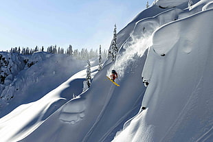 man with snowboard on white snow covered mountain