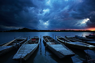 five brown row boats on  body of water