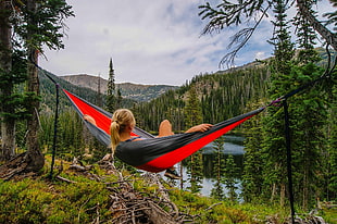 woman in blonde hair lying on red and black hammock during daytime HD wallpaper