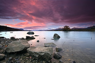 rocks on river shore under purple sky