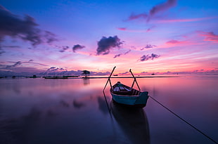 white canoe on sea at daytime