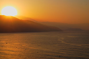 body of water under sunset