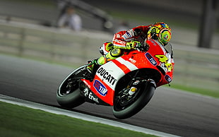 racer in red biker suit riding Ducati sports bike HD wallpaper