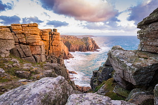 panoramic photo of rocks and beach during daytime HD wallpaper