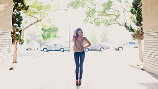woman wearing brown blouse, blue denim jeans and black sandals standing near parked vehicles during daytime HD wallpaper