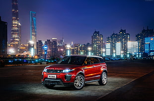 red Land Rover Range Rover on black top road during night time