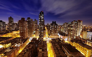 lighted high-rise building in the city during nighttime HD wallpaper
