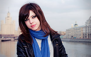 woman wearing blue scarf taking a picture infront of white structure during daytime