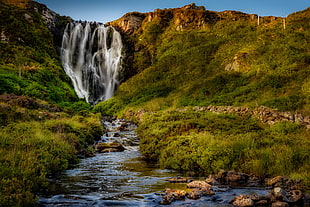 water fall on mountain under blue sky HD wallpaper