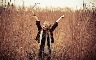 woman in black long sleeve shirt between grass field