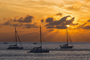 three yacht on large body of water under cloudy sky during sunset, thailand