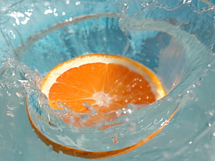 time lapse photography of sliced orange fruit splashed on water HD wallpaper