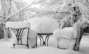 gray scale photography of 3-piece table and chairs covered with snow