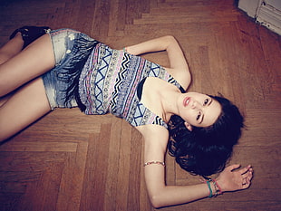 woman lying on brown wood parquet flooring