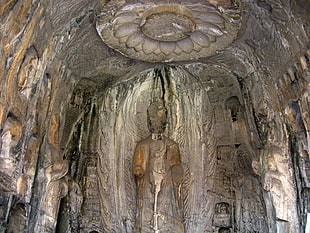 ancient statue engravings on wall interior during daytime