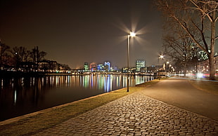 street light beside river during night time HD wallpaper