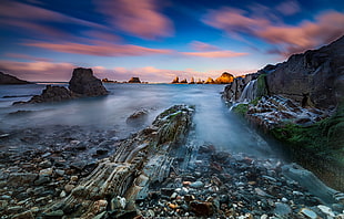 rock formation near body of water during daytime