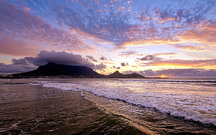 waves rushed to shore at sunset