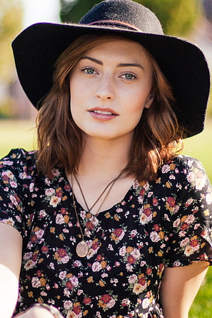 woman in black and pink floral dress and black hat