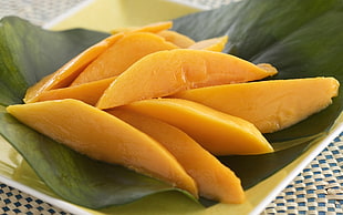 sliced mango on green leaf plant HD wallpaper