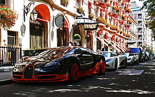 red and black Bugatti Veyron beside concrete structure HD wallpaper