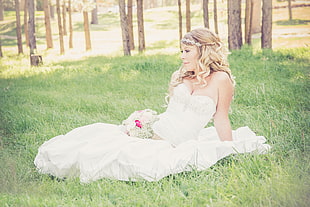 woman in white sweetheart bridal gown sitting on grass during daytime HD wallpaper
