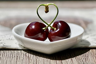 two cherries on white ceramic saucer HD wallpaper