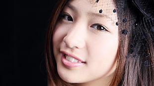 close-up photo of woman wearing black headdress with pink lipstick