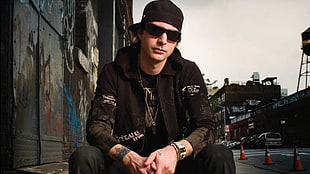 man in black jacket, sunglasses, and cap near graffiti wall HD wallpaper