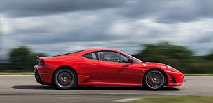 depth of field photography of red coupe on road during daytime, nogaro