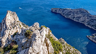 top view of rock mounted beside blue body of water