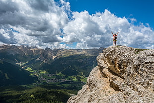 person standing in edge of cliff during daytime