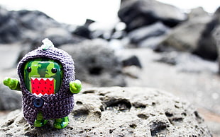 shallow focus on green domo kun figure with purple knitted sweater HD wallpaper